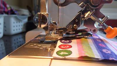 Insert a test strip into the ruffler foot. Insert a test strip into the ruffler foot.